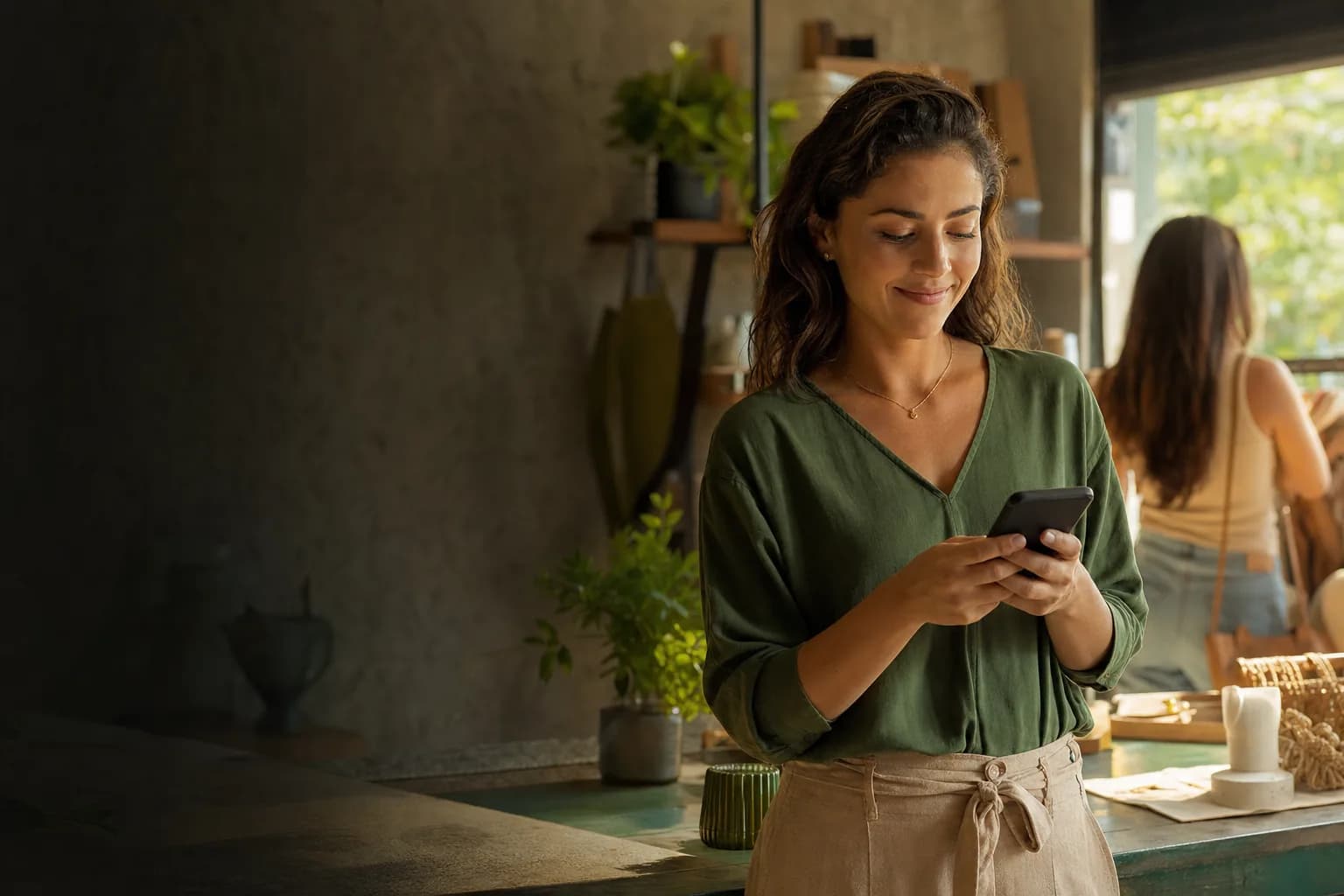 Empreendedora confiante consultando uma mensagem no celular em seu negócio