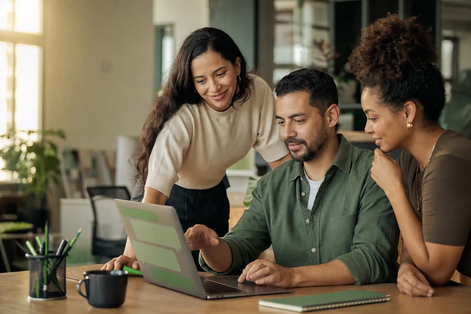 Equipe de atendimento colaborando ao redor de um notebook